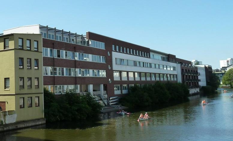 Exterior view of the brick and white facade of Satellite Alster, Hans-Henny-Jahnn-Weg 53.