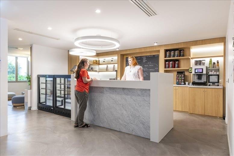 On-site cafe and refreshment bar with a marble counter and circular pendant lights.