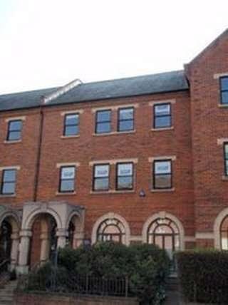 Red brick exterior view of 56/58 Queens Road, Reading, Berkshire with arched ground floor windows.