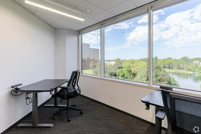 Private office at 1st Floor, 56-60 St John Street with height-adjustable desks and views of a park and lake.