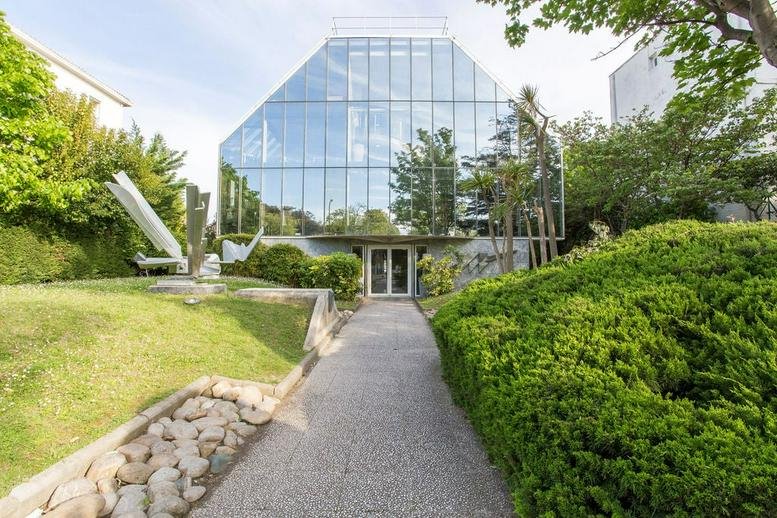 Exterior view of the glass-facade building at 565 Avenue du Prado.