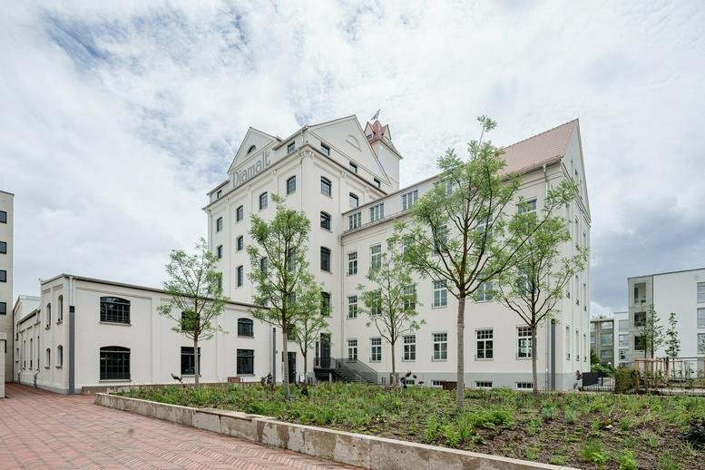 Exterior view of the historic white brick facade at the Diamalt Factory Site.