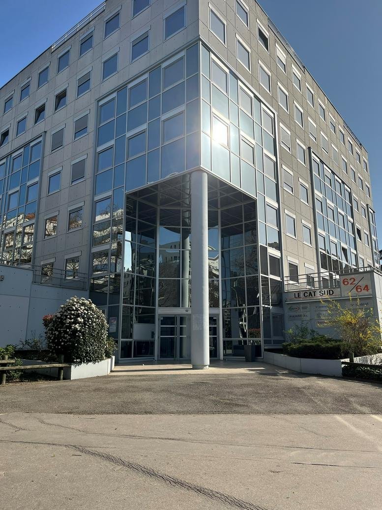 Exterior view of the glass-facade 62 Cours Albert Thomas building with its central recessed entrance.