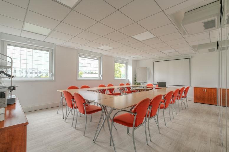 Large meeting room at 62 Cours Albert Thomas with orange chairs and whiteboards.