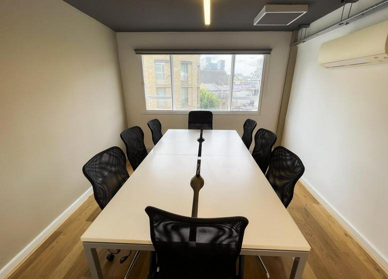 Spacious boardroom with a large white table and ergonomic mesh chairs at 64 Great Eastern Street.