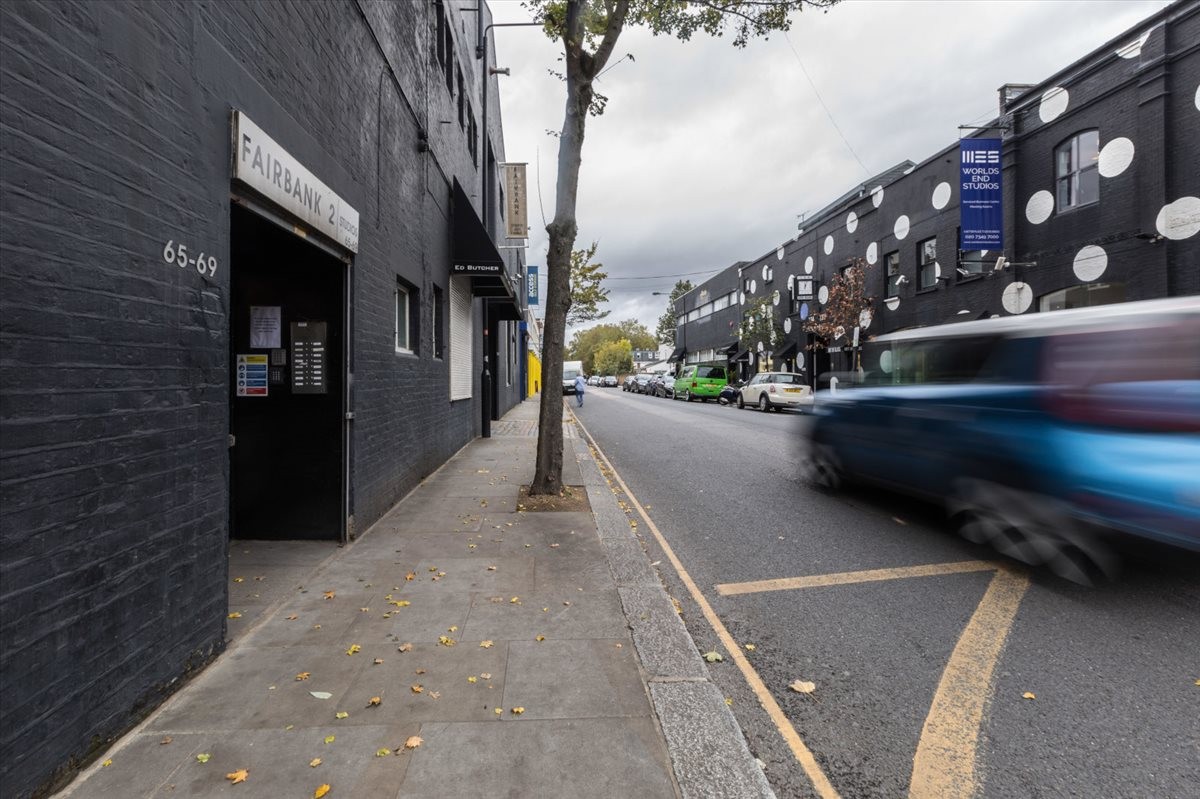 Exterior of 65/69 Lots Road with black brick facade and white circle patterns on adjacent buildings.