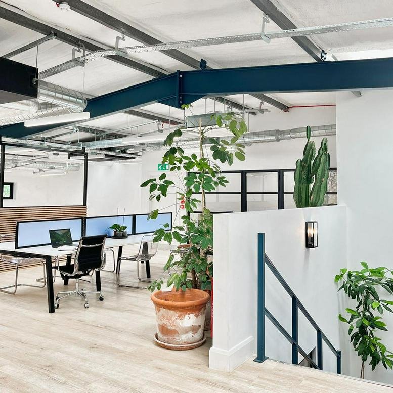 Spacious open-plan workspace at The Green Design Hub, 7 Greenlea Park with large potted plants and industrial ceilings.