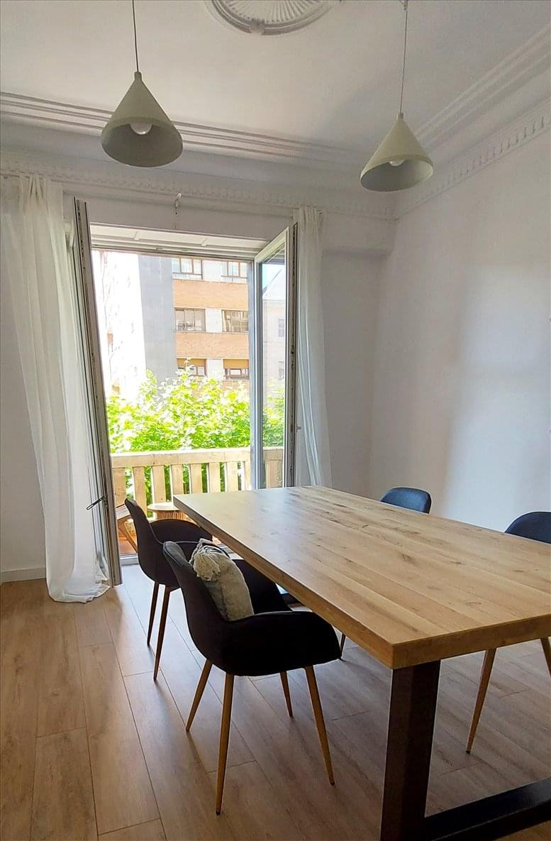 Spacious reception area with a light wood desk, modern chandelier, and large windows.