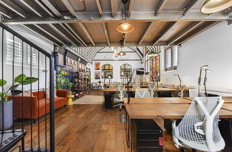 Spacious interior of Top Floor, 70-71 Wells Street featuring open-plan desks and a leather sofa.