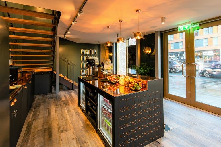 Spacious communal cafe and lobby at The Astley, 70 Great Ancoats Street, featuring a modern service island.