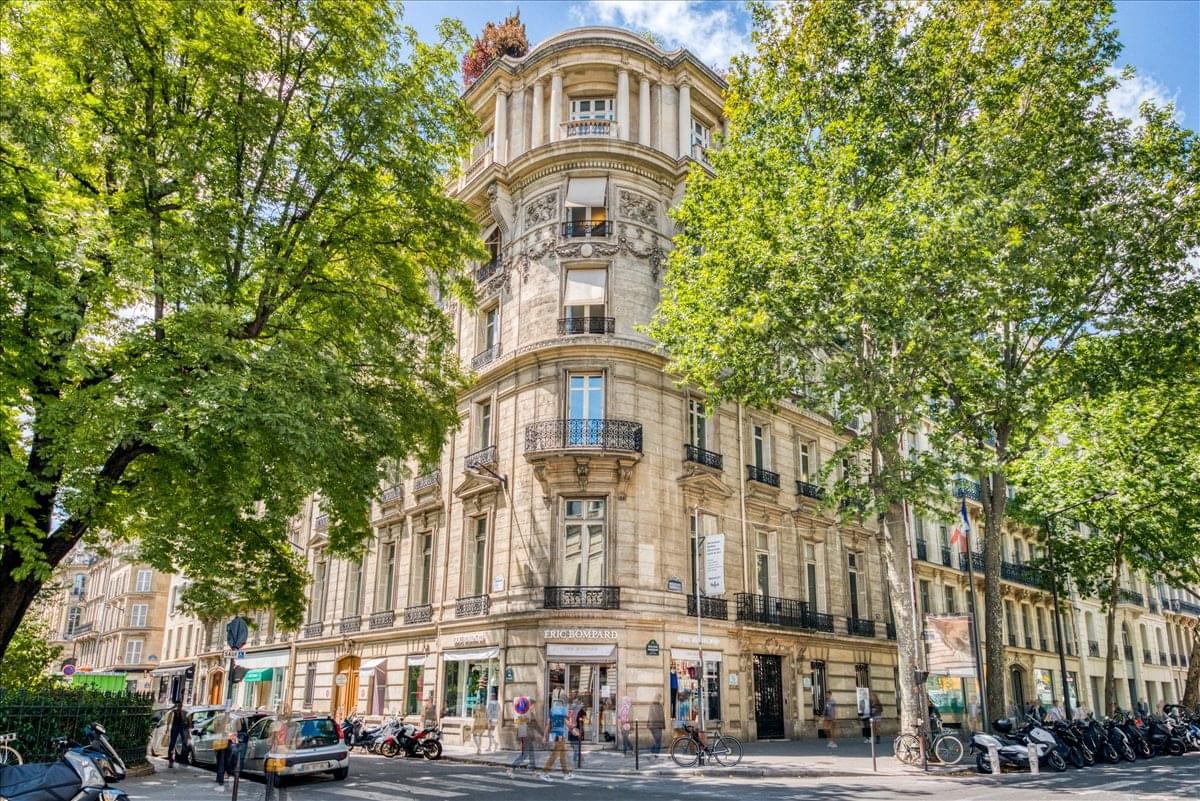Grand exterior view of the historic stone corner building at 75 bld Haussmann, Paris.