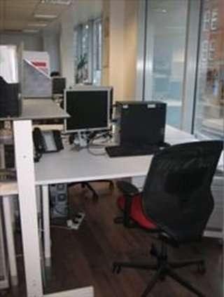 Spacious office workstation at 79 Clerkenwell Road with multiple monitors and an ergonomic mesh chair.