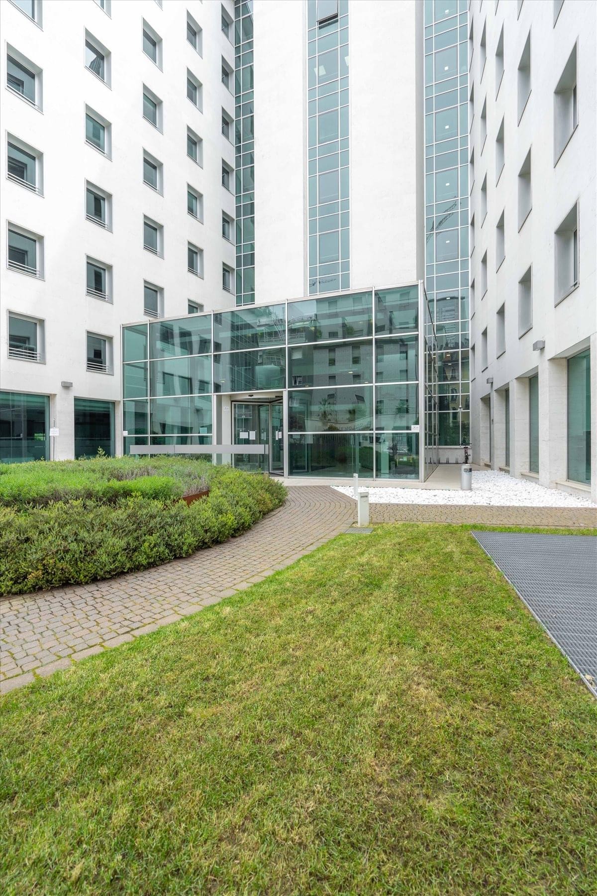 Modern communal lounge at 8/10 Via Roberto Lepetit, Milan, Italy with plush seating and industrial ceilings.