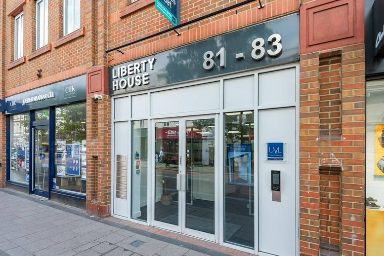 Street-level entrance to Liberty House featuring glass doors and red brick facade.
