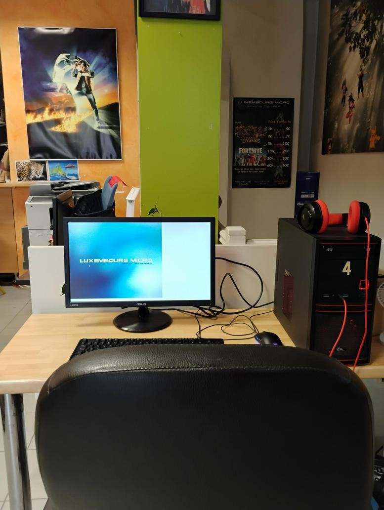 Individual workstation featuring a red headset, black PC tower, and movie posters on the wall.
