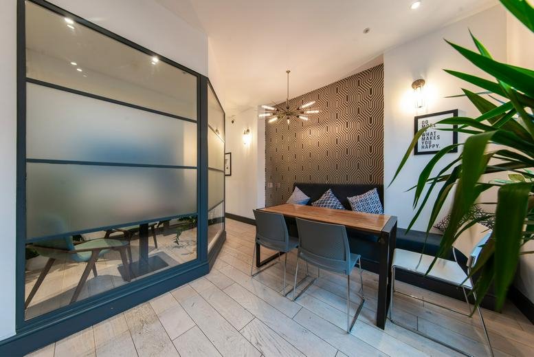 Meeting room at 82 Rivington Street featuring a long wooden table and frosted glass partitions.
