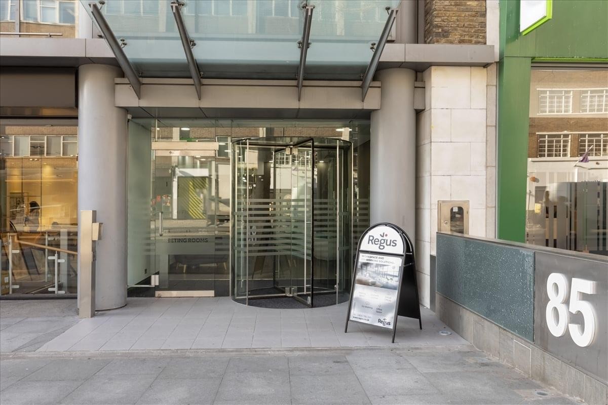 Building entrance with revolving glass doors at 85 Tottenham Court Road.