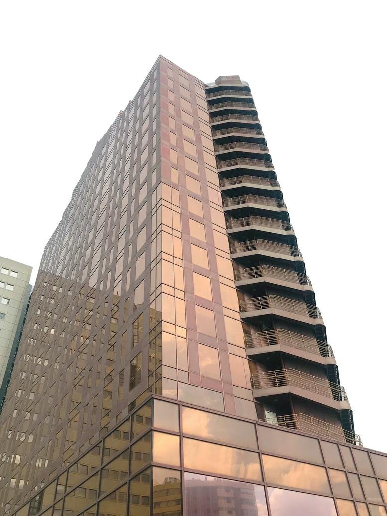 Low-angle exterior view of the glass-facade Edificio Bronce skyscraper.