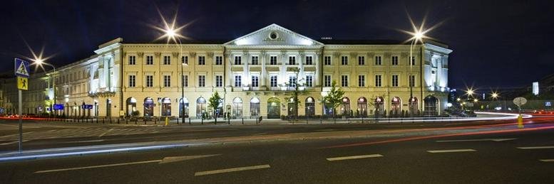 Exterior night view of the grand classical building at 9/11 Wierzbowa Street, Warsaw, Poland.