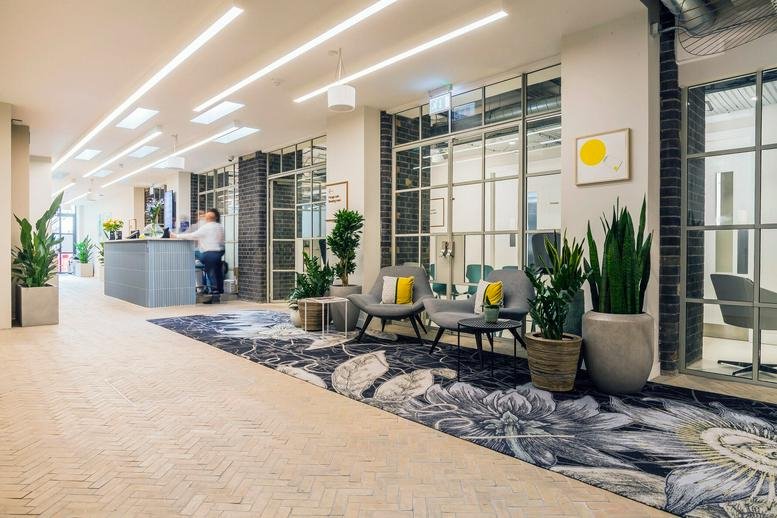 Spacious reception area at 9 Dallington Street, Central London featuring a floral rug and grey seating.