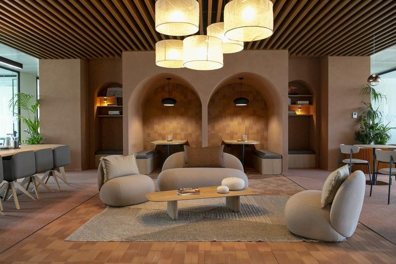 Warm, designer lounge at Stella Santa Giulia with curved sofas, arched alcoves, and textured ceiling.