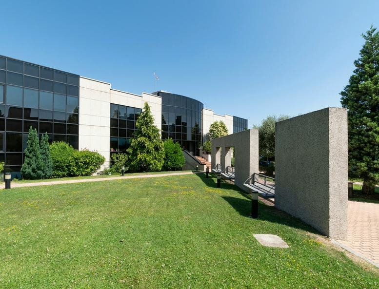 Modern exterior of the E Building, Miniparc III with glass facade and surrounding green lawn.