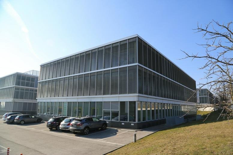 Exterior view of the modern glass facade of A1 Business Center, La Pièce 1, A5, Rolle, Switzerland.