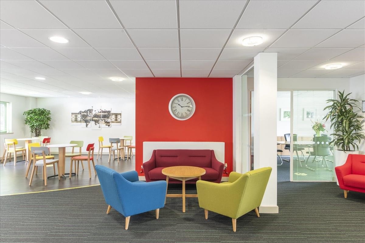 Colorful breakout lounge at Adur Business Centre with red, blue, and green seating.