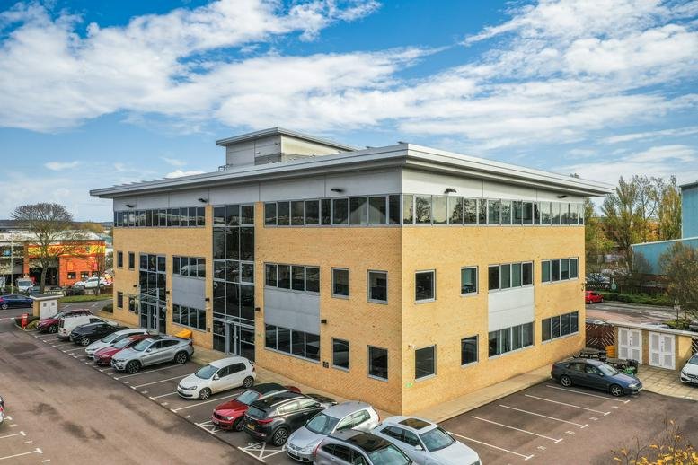 Exterior view of Albany Chambers, a modern brick and glass building with ample parking.