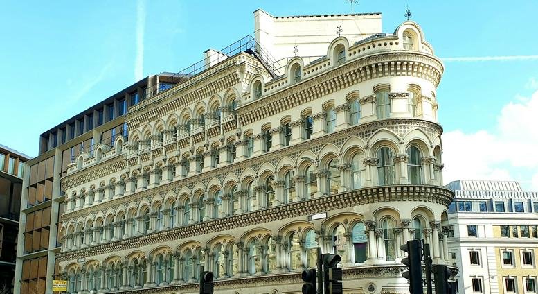 Ornate stone facade of Albert Buildings, 49 Queen Victoria Street with arched windows and classical detailing.