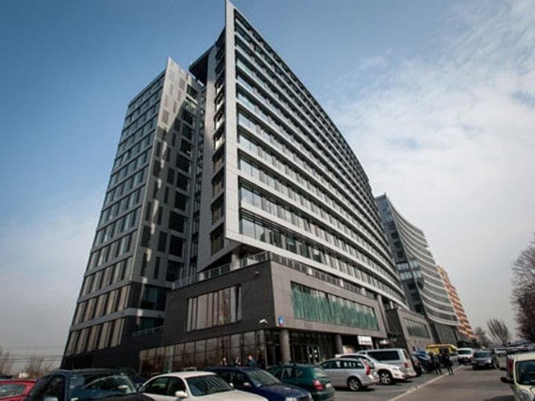 A dramatic low-angle exterior view of the modern glass and steel facade at Aleje Jerozolimskie 96.