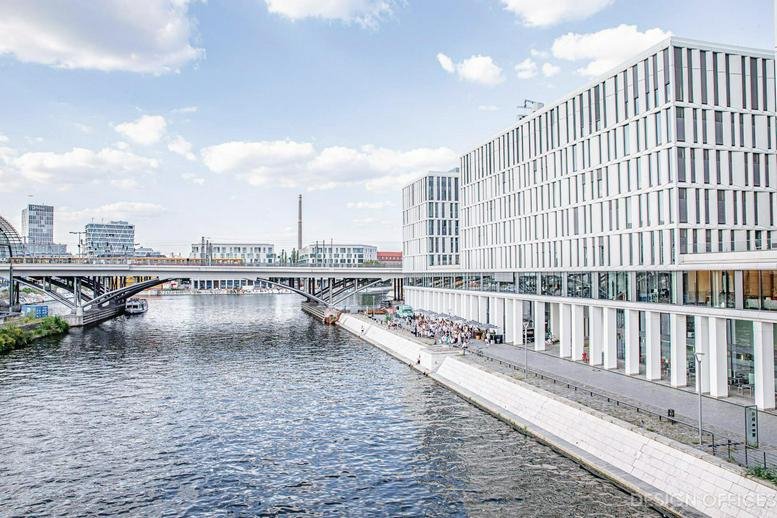 Exterior view of the modern glass-facade Alexanderufer 3-7 building situated along the river.