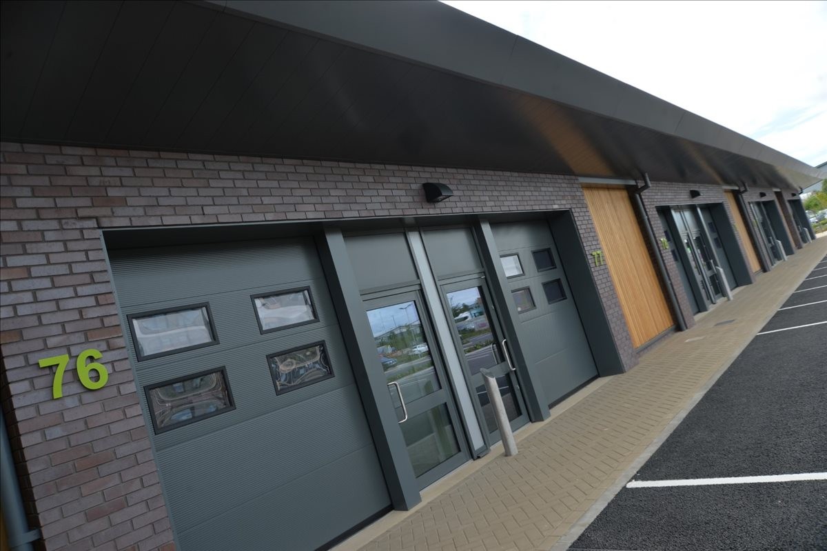 Modern exterior facade at Amberley Road, Off Tong Road, Wortley, Leeds, featuring dark brick and garage doors.