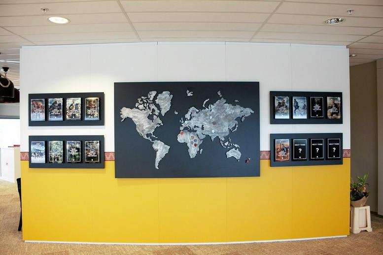 Feature wall with a large world map and framed awards at Amsterdam Oval Tower.