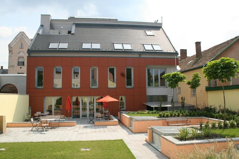 Exterior view of the red brick and grey roof building at Arany Janos u. 55, Debrecen, Hungary.