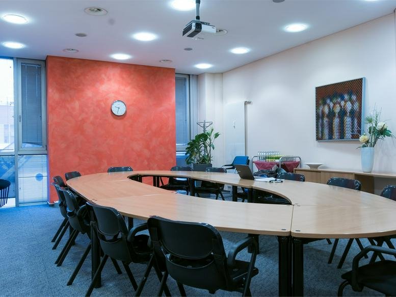 Spacious boardroom at Arena Graz, Liebenauer Hauptstraße 2-6 with a curved table and red feature wall.