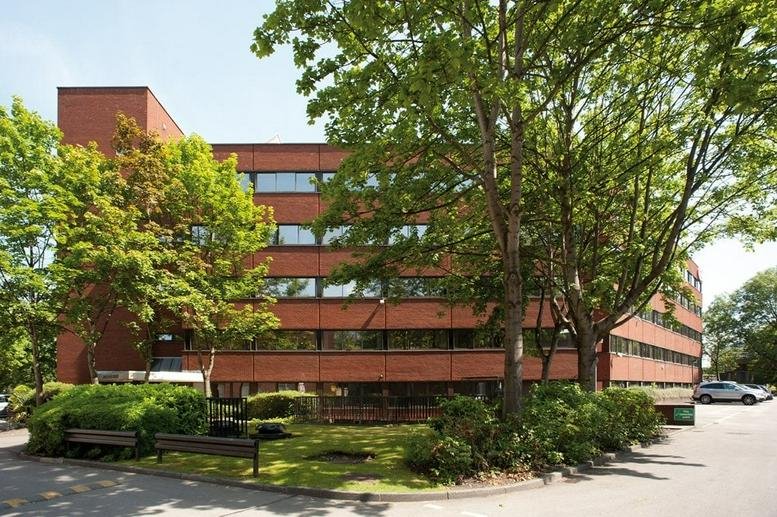 Exterior view of the red brick Armstrong House, Manchester Technology Centre, Oxford Road building with mature trees.