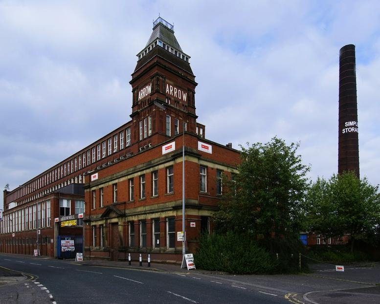 Exterior view of the historic red brick Arrow Mill, Queensway featuring a prominent square tower.