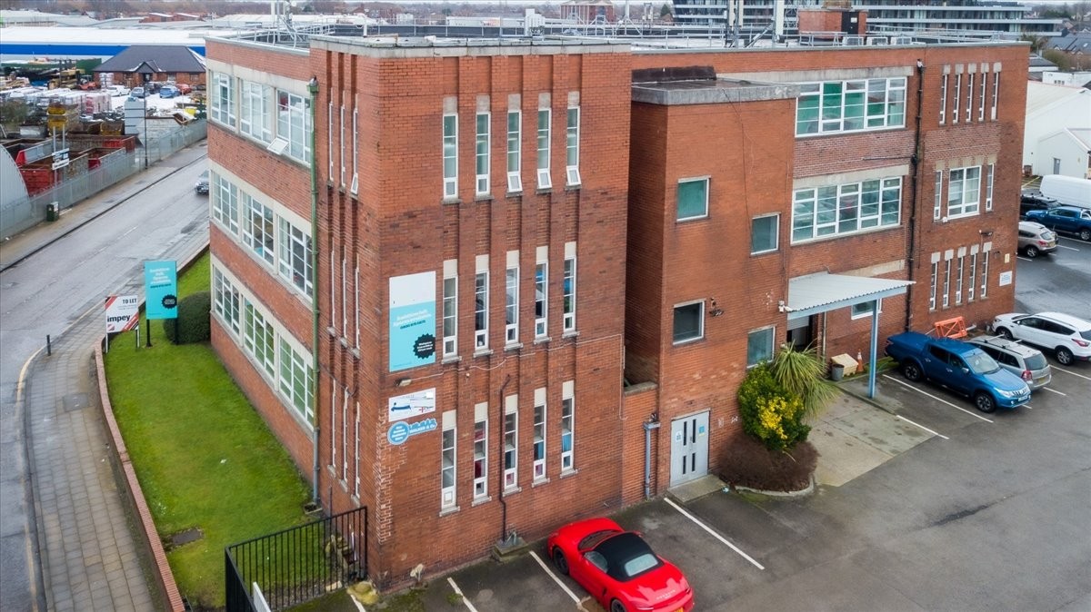 Exterior view of the red brick Atlantic Business Centre featuring large industrial-style windows.
