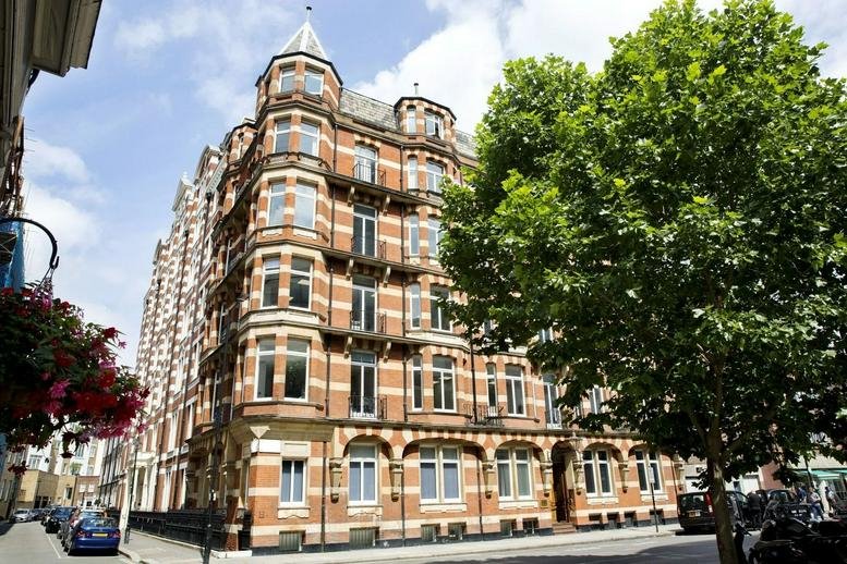 Exterior facade of Audley House, 13 Palace Street, a red-brick building with rounded bay windows.