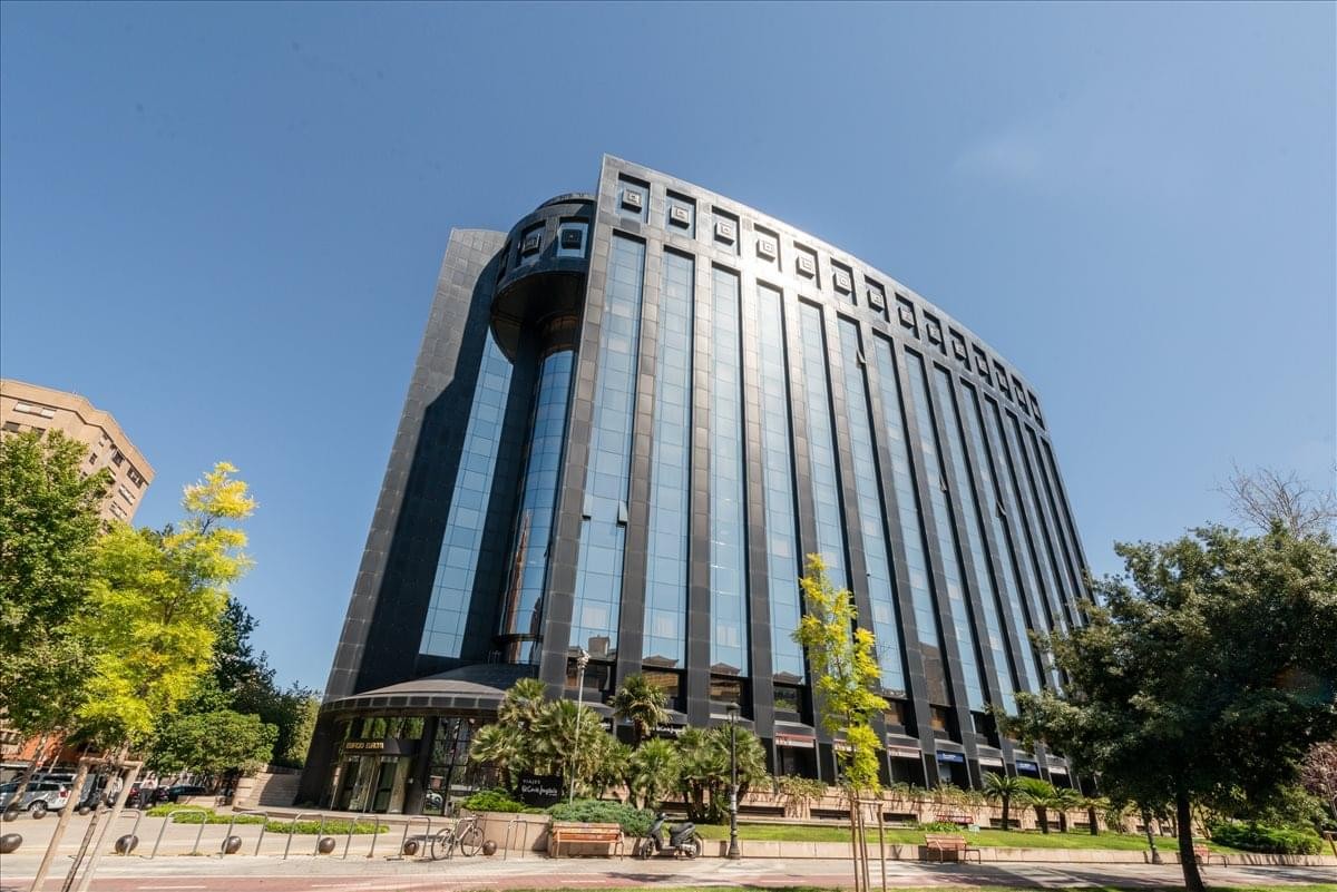 Exterior view of the dark glass facade of Avenida de Aragón 30, Valencia.