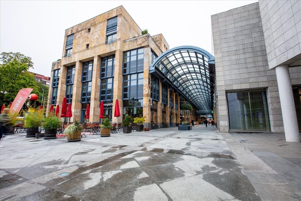 Exterior view of the stone facade and glass atrium at Baarerstrasse 14-16, 2nd Floor, Zug, Switzerland.
