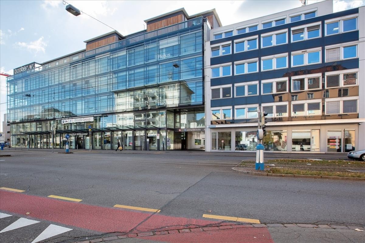 Modern glass and stone facade of the Badenerstrasse 549 building in Zurich.