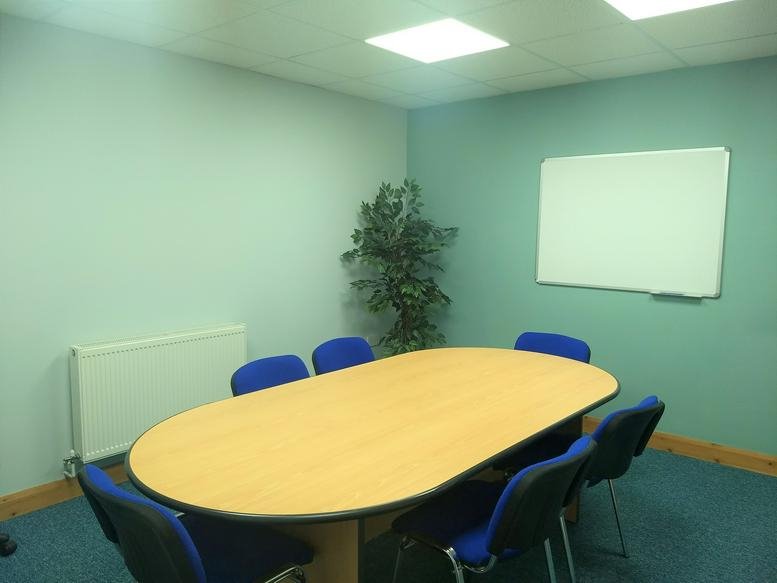Meeting room at Barbury House, 8 Hardy Close, Preston, featuring an oval wooden table and blue chairs.