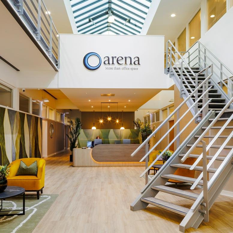 Bright modern reception area with wooden floors and a stylish staircase.