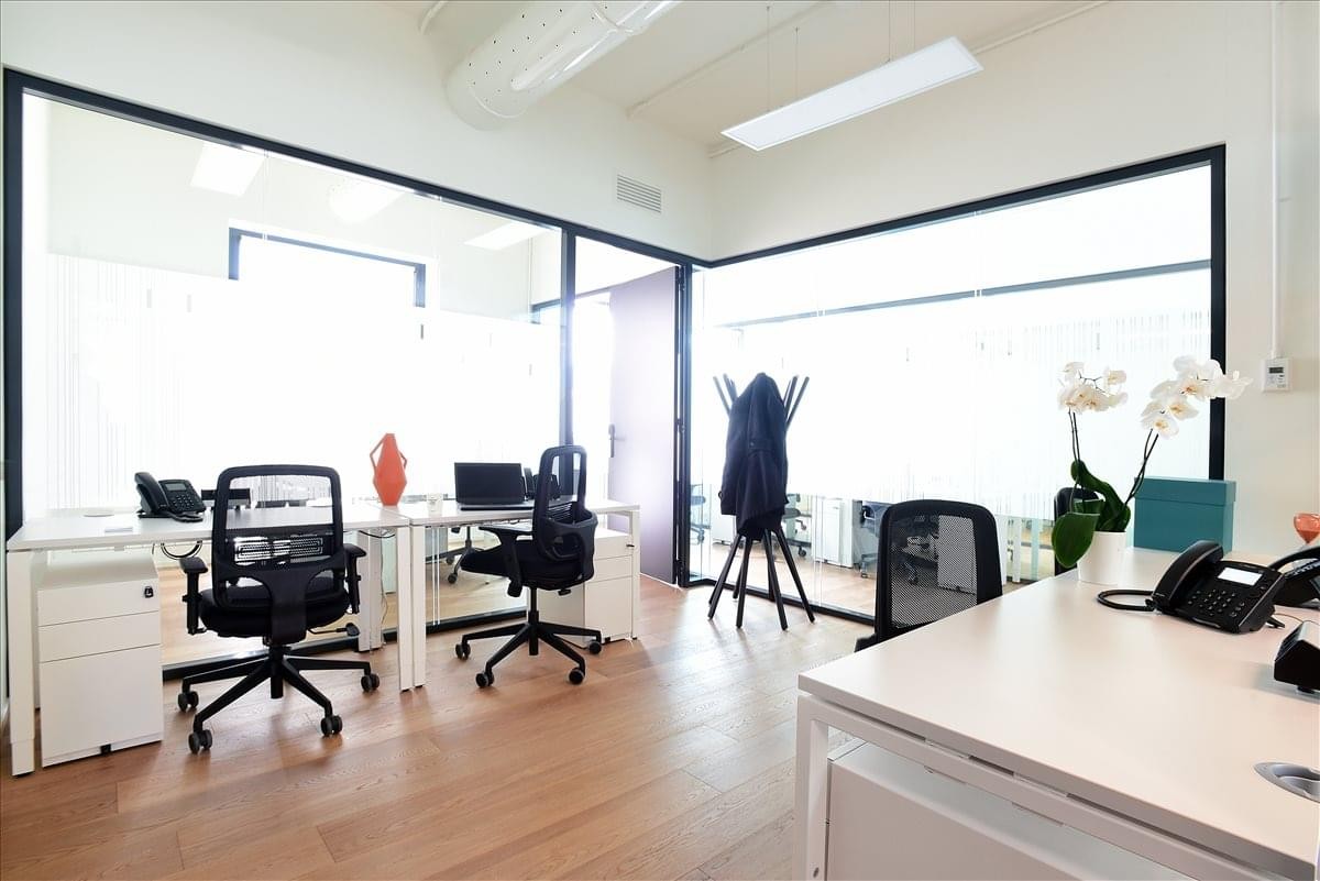 Spacious interior lobby area at Bastioni di Porta Nuova 21 with desks and glass partitions.
