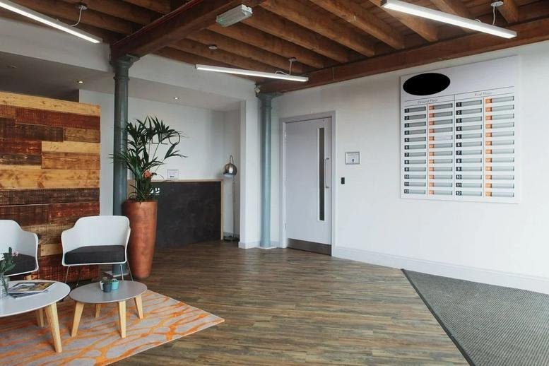Welcoming entrance lobby at Beck Mill, Reva Syke Road, featuring timber ceilings and a directory board.