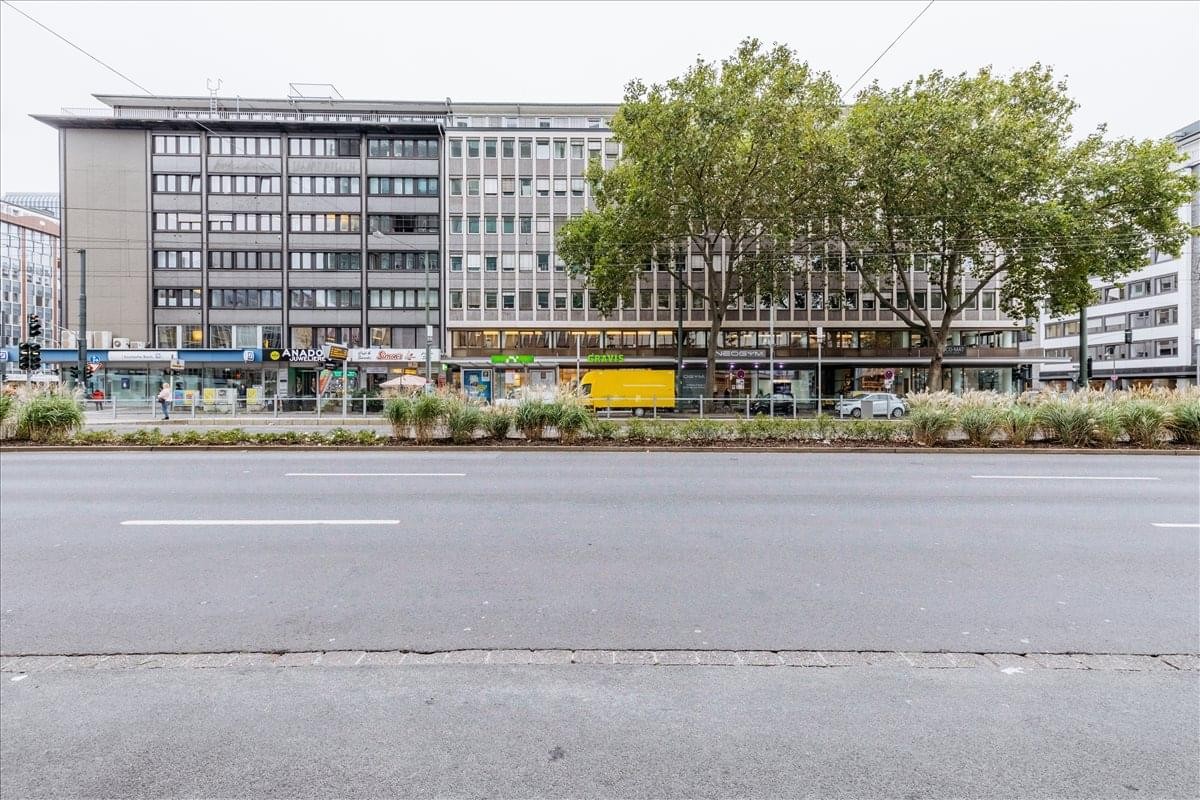Exterior view of the multi-story office building at Berliner Allee 59 with ground-floor shops.