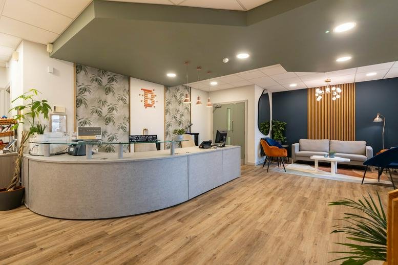 Spacious reception area at Bicester Innovation Centre, Commerce House, featuring a curved desk and soft seating.