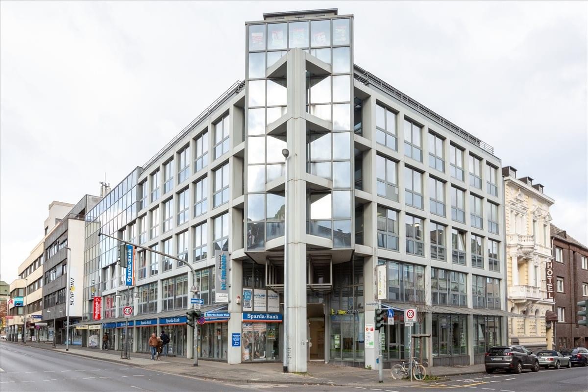 Modern corner exterior of the glass and concrete Bismarckstrasse 100 building.